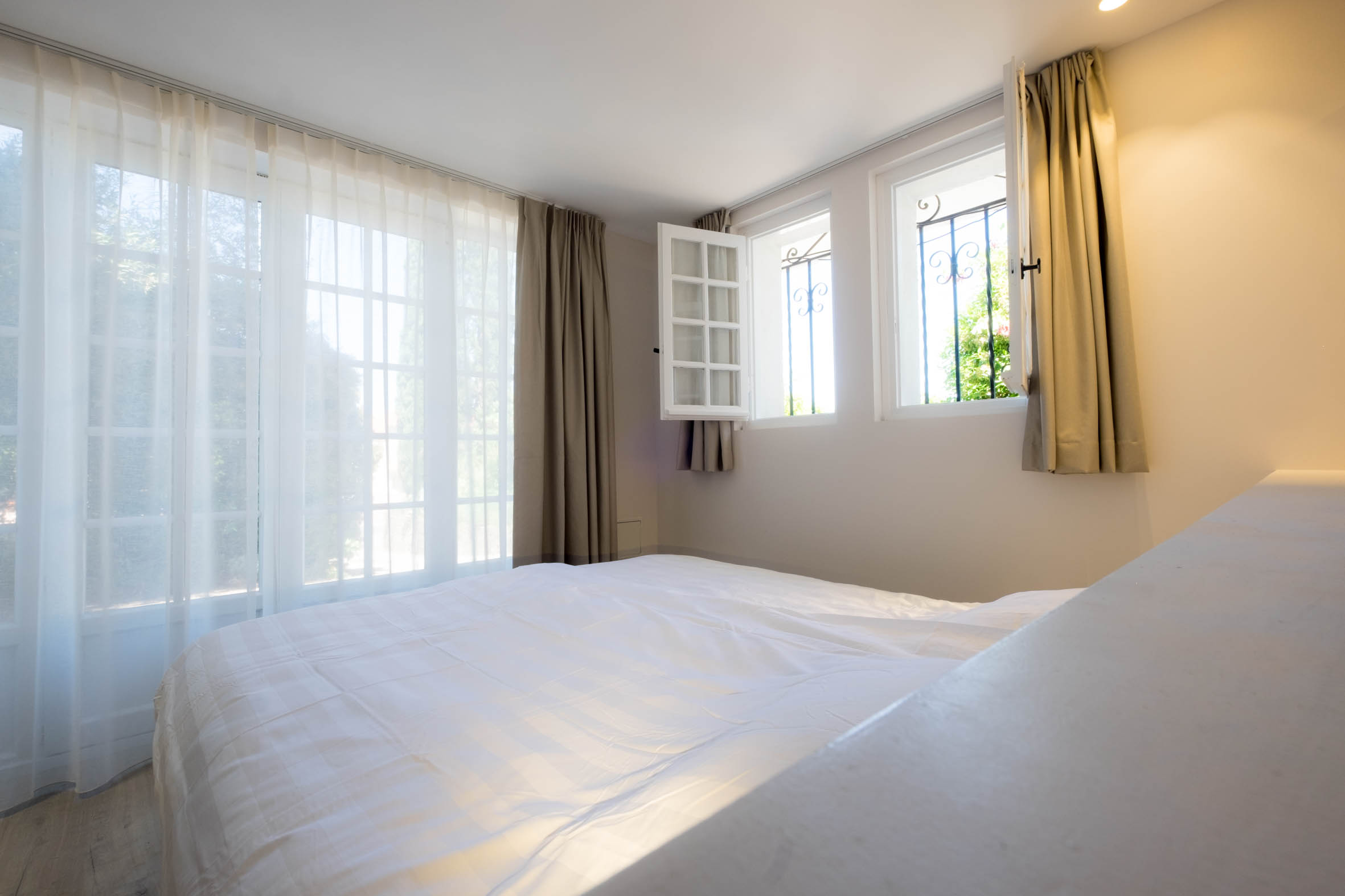 Chambre Cerise mit transparenten Vorhängen und bodentiefen Fenstertüren