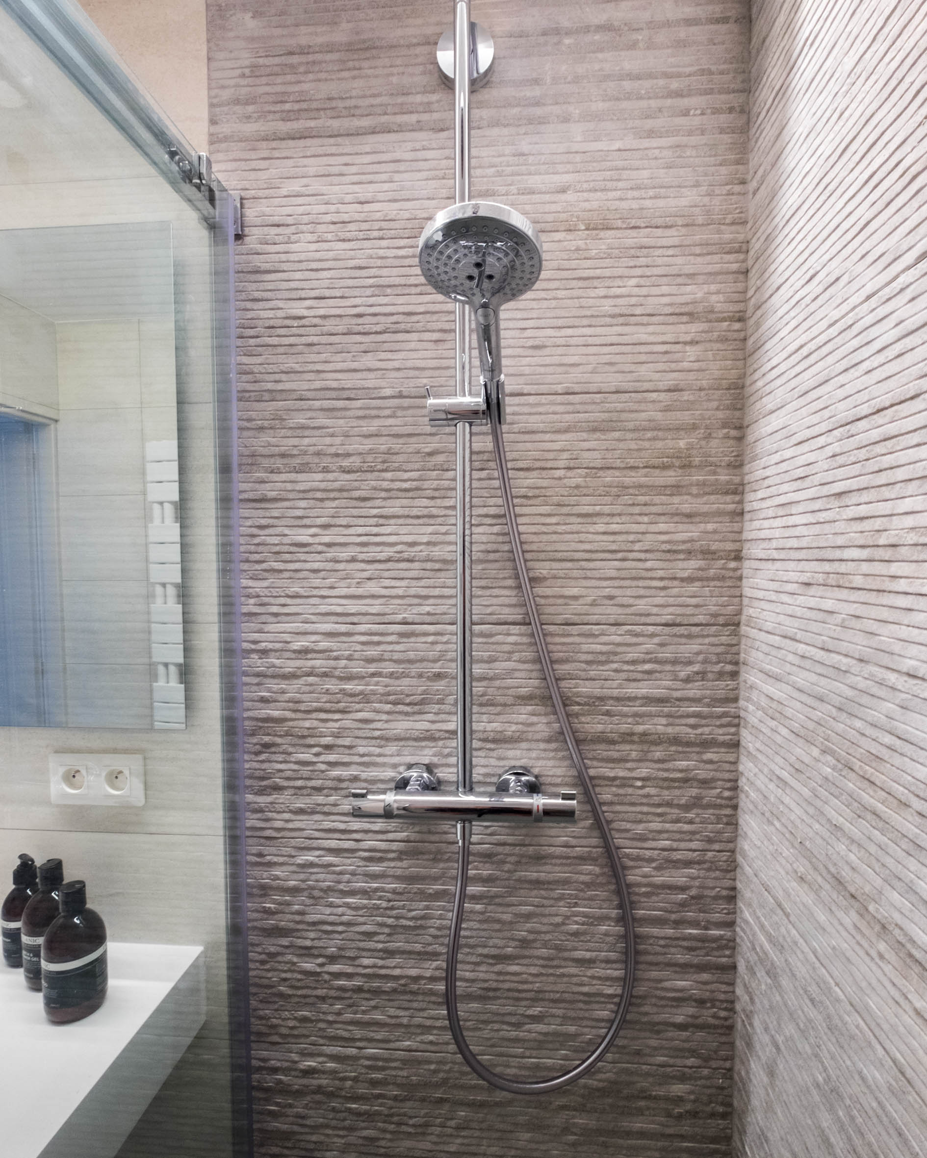 Doccia a pioggia con piastrelle effetto pietra nel bagno di Alosa Terrace
