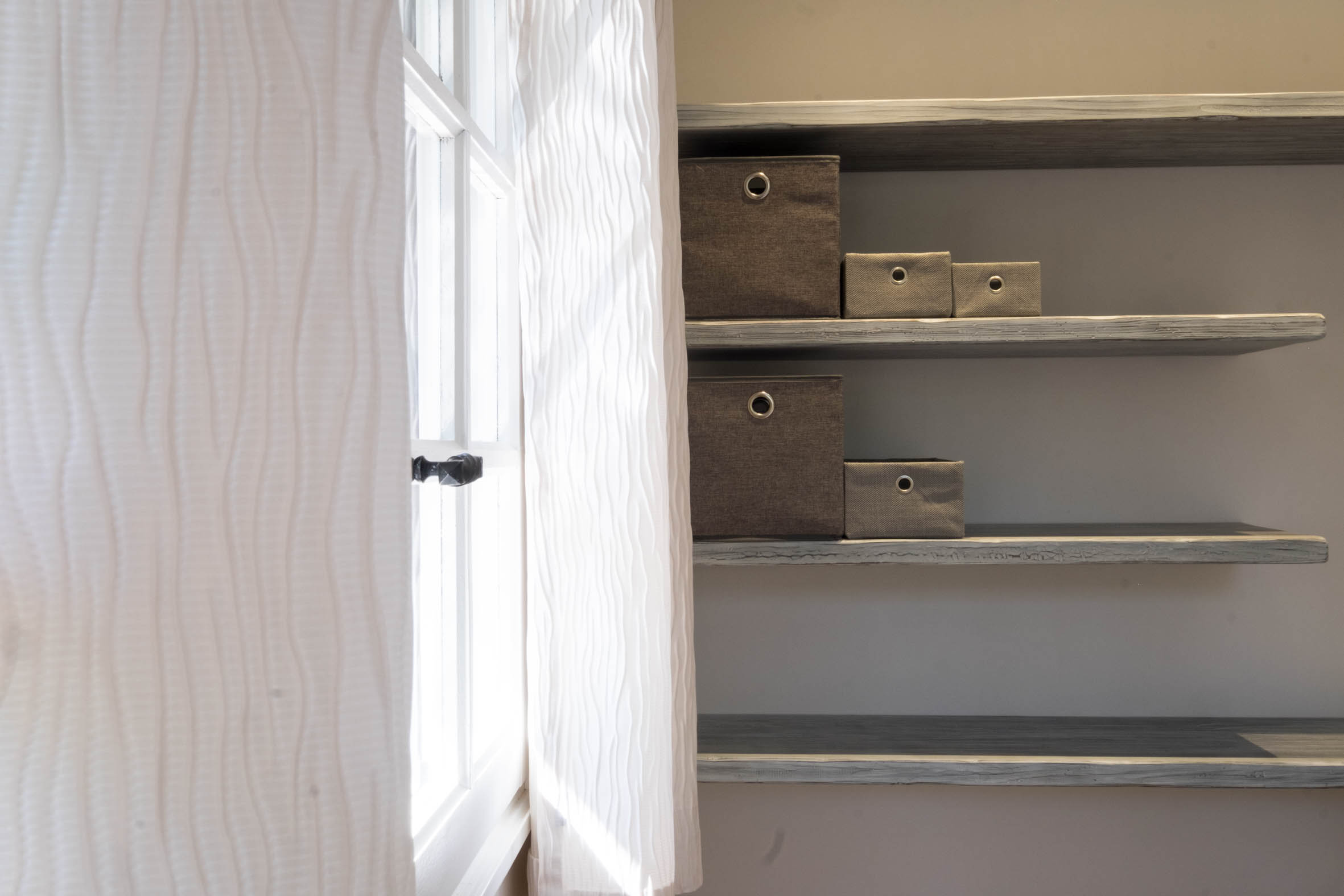 Estantes con cajas de almacenaje junto a la ventana de la Chambre Olivier