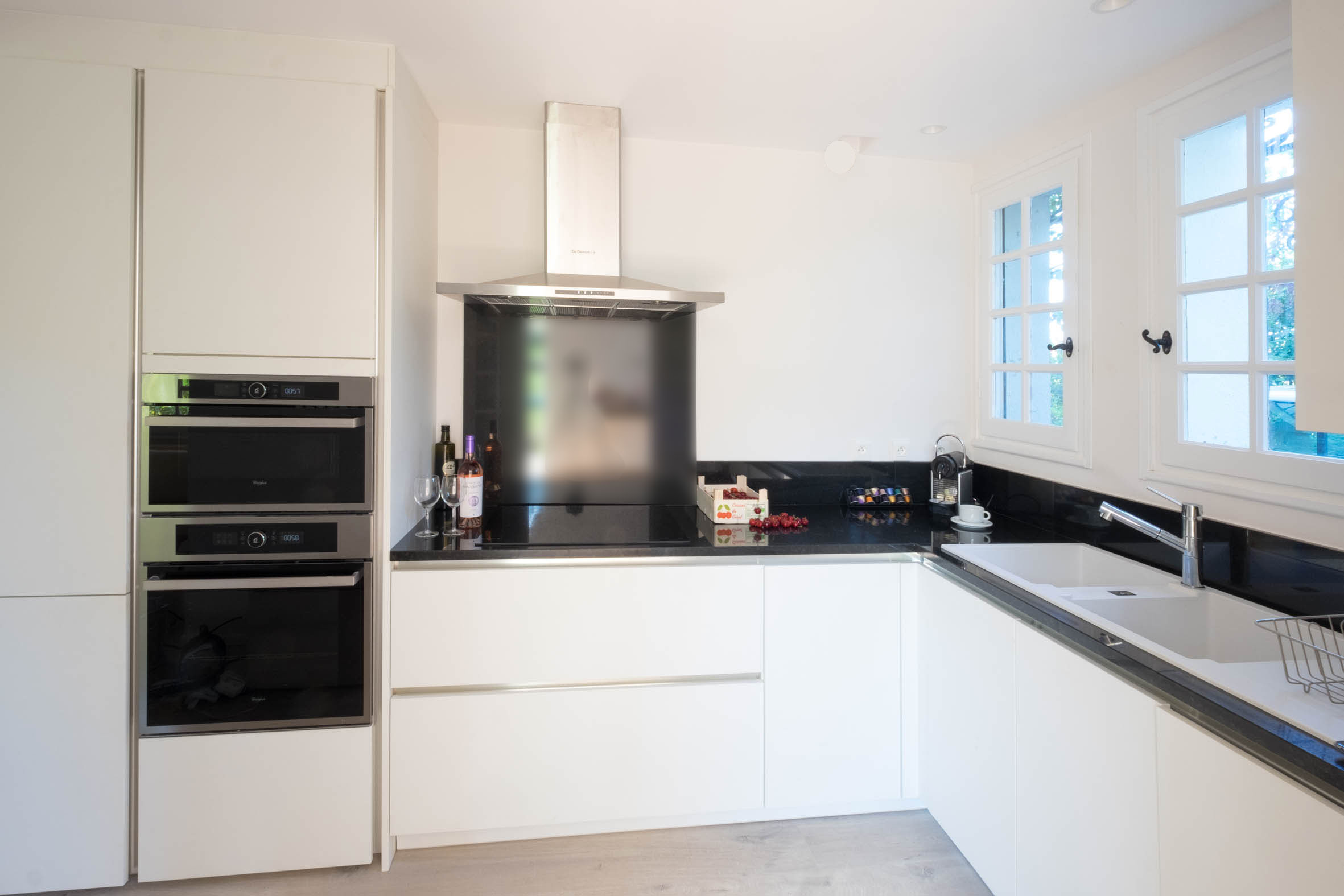 Cocina de Alosa Terrace con muebles blancos y encimera negra