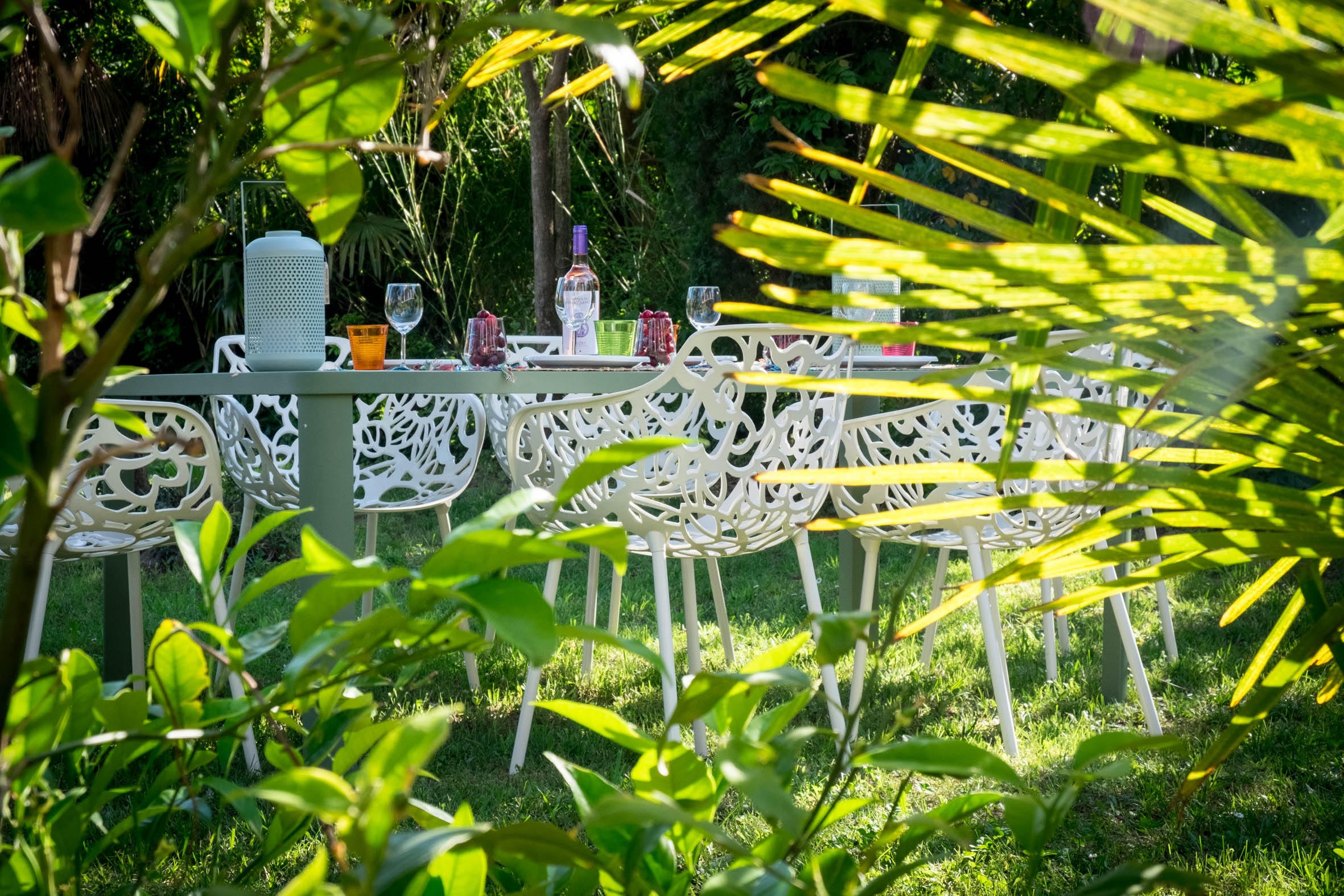 Table laid for lunch in a green corner of the Villa Alosa garden