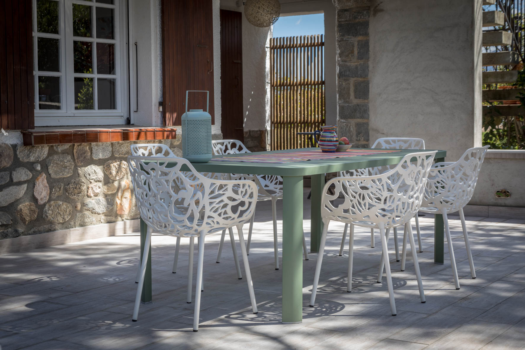 Esstisch im Freien mit weißen Stühlen auf der Terrasse von Alosa Terrace