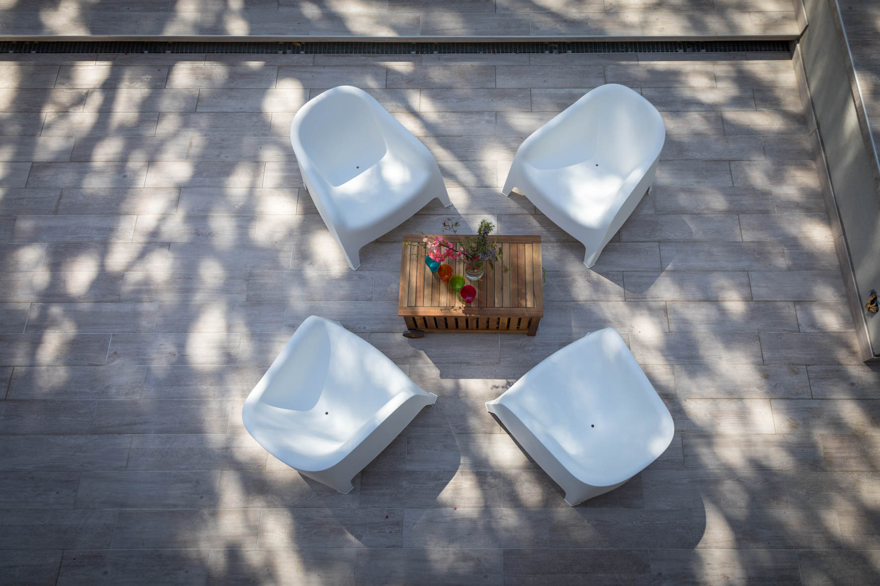 Weiße Loungesessel um einen niedrigen Tisch auf der Terrasse von Alosa Terrace, von oben