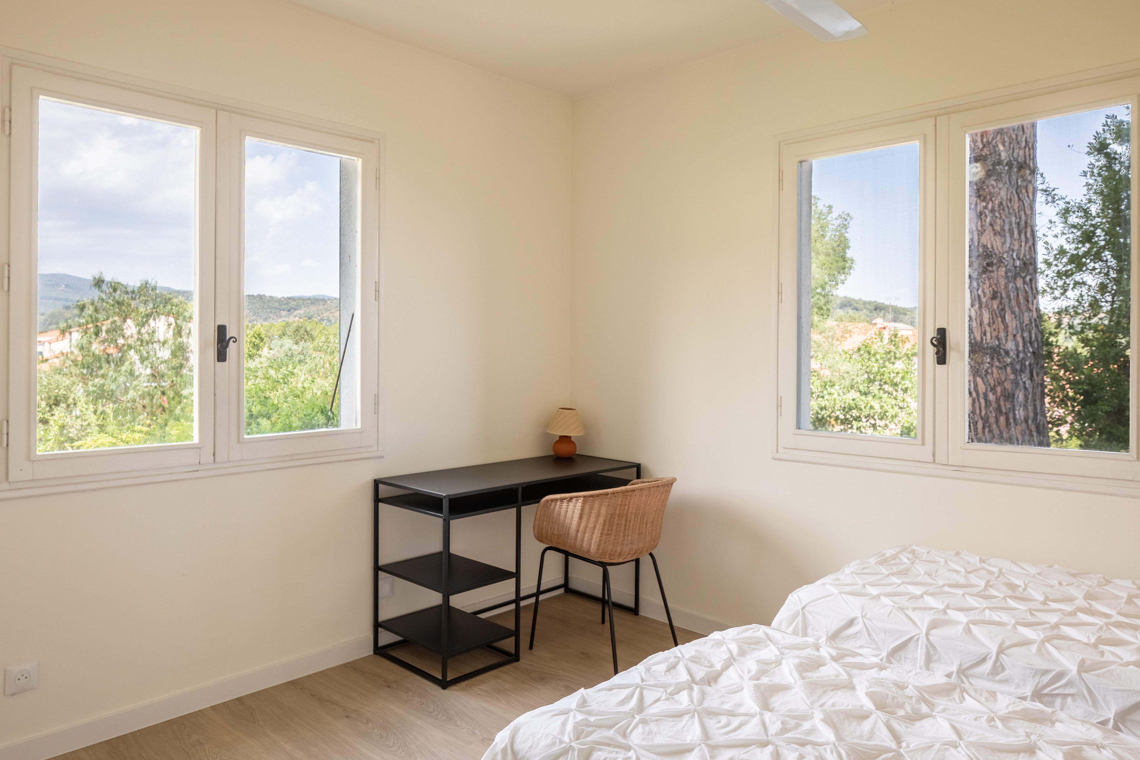 Slaapkamer Le Tech in Alosa Balcon met een klein bureau en ramen met zicht op de pijnbomen