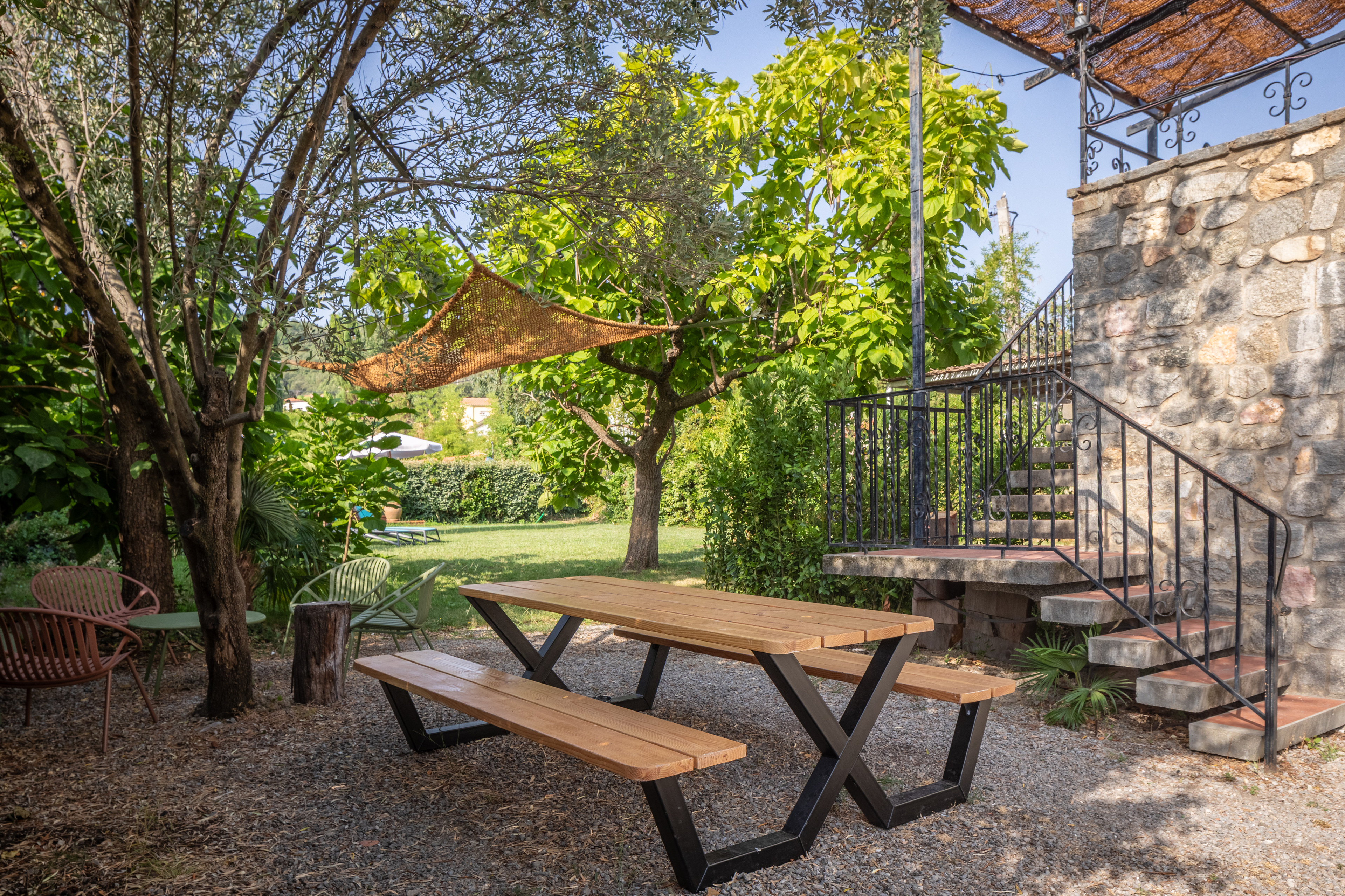 Steinerne Außentreppe hinauf zu Alosa Balcon, unten im Garten ein Picknicktisch