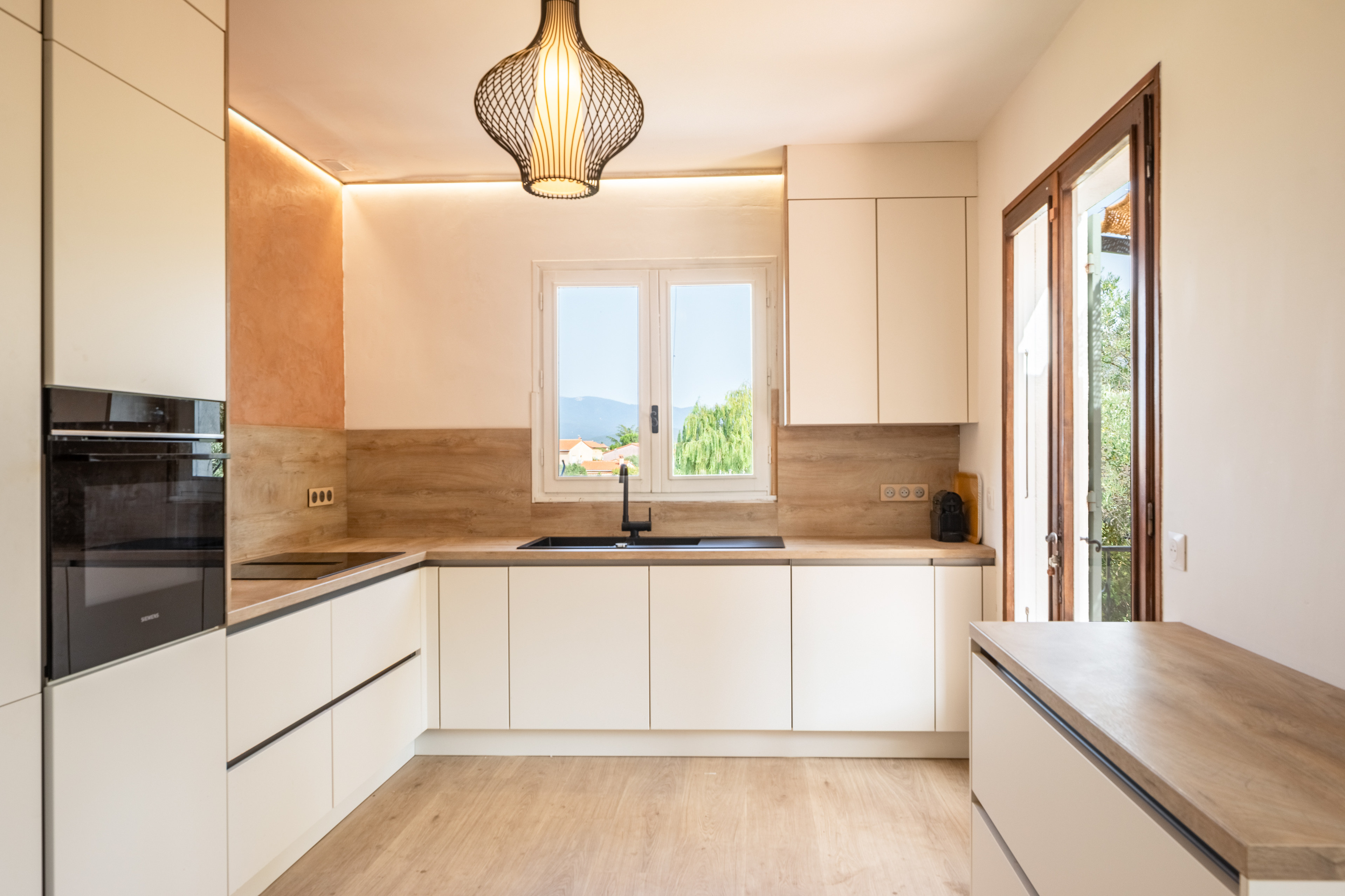 Küche von Alosa Balcon mit weißen Schränken, Holzarbeitsplatte und Einbaubackofen